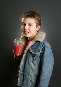 Child drinking healthy fruit juice containing apple and berries.