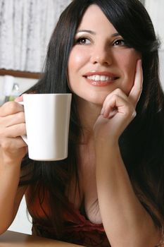 Woman sitting down with a cup of hot coffee