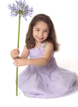 Pretty smiling girl holding a purple flower.