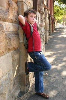 A child resting against a sandstone brick wall.
f5