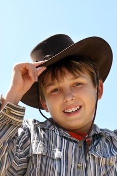 A country boy wearing brown hat and shirt, with a warm friendly smile.