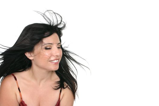 Brunette woman with long brunette hair blowing freely in the breeze.