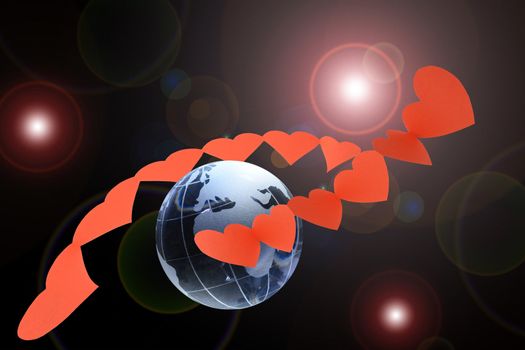 Red paper heart chains around glass globe on dark background