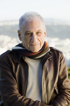 Portrait of a Senior Man in a Scarf and Leather Jacket Looking Directly To Camera