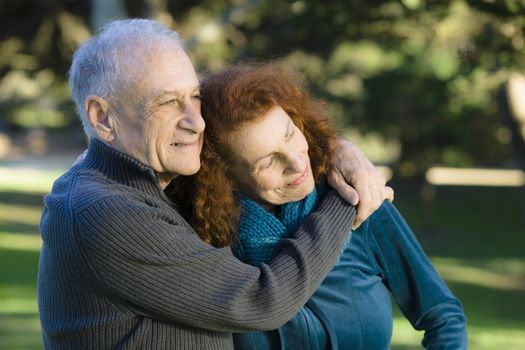 Smiling Senior Couple Embracing Each Other in a Park
