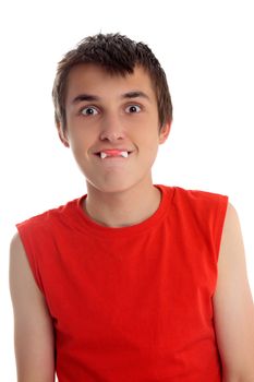 A boy pulling a funny face with a dracula teeth confectionary soft candy in his mouth.