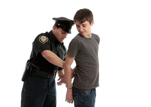 A police officer arrests and handcuffs a young male teen felon.