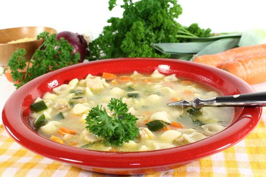 a cup of chicken soup with fresh vegetables