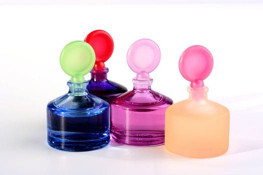 Colour small small bottles with cosmetics for care of a skin on a white background.