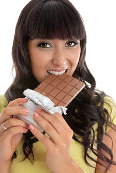 Closeup of a beautiful lively happy young woman eating from a chocolate block.