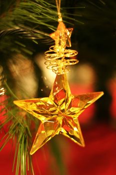 Golden star hanging on Christmas tree.