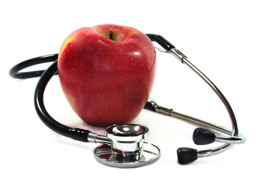 Stethoscope with apple on white background