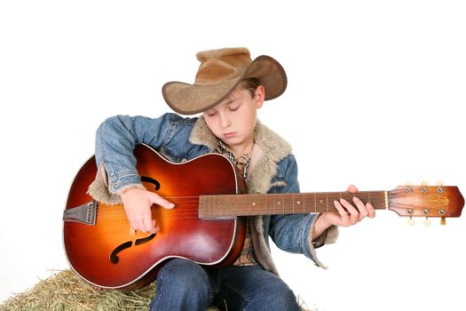 A boy strums a tune on an acoustic guitar