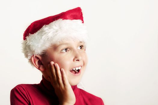 Gleeful happy child wearing a red Santa hat