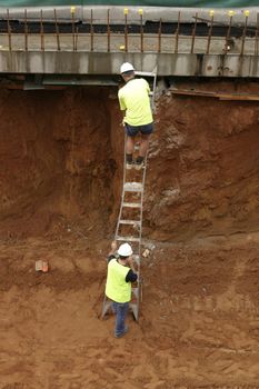 Workman on a ladder in a construction site.
