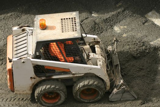 Bobcat scooping up gravel
