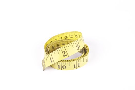 Yellow curled tape measure with a reflective white background