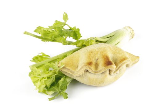 Contradiction between healthy food and junk food using celery and pasty on a reflective white background 