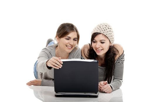 Two female young students working with a laptop