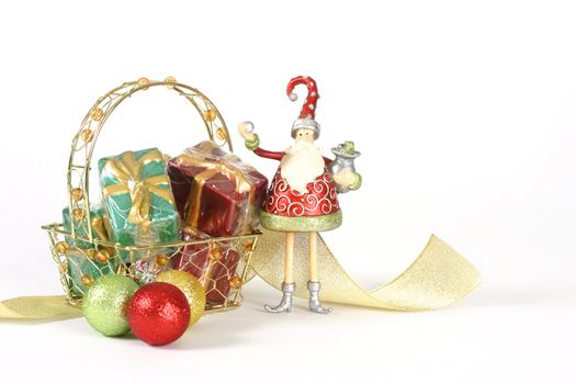 A basket of presents,glitter baubles, ribbon and christmas elf on a white background.