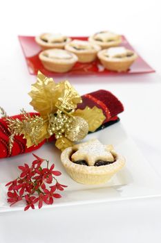 Sweet fruit mince pies.   Red Australian Christmas bush decorative napkin.  Focus on foreground.