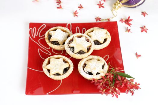 Christmas tarts on a decorative plate with ornamental Australian Christmas bush flowers.