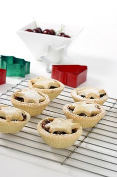 Small fruit pies with star decorations sitting on a wire cooler.  Focus on foreground.