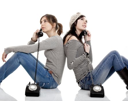 Two young women talking with old telephones - Isolated on white