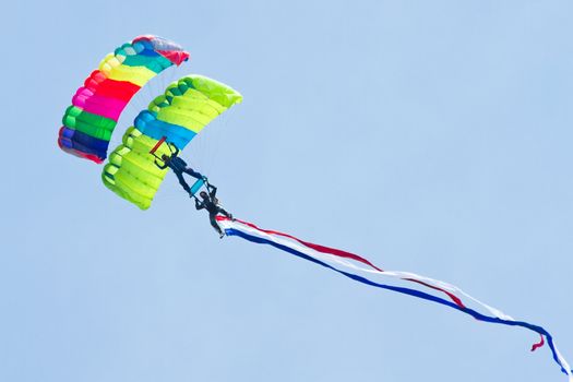 Skydiving - Parachutists demonstrate jumping from airplane. One standing on the others shoulders.