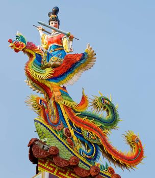 Chinese god carving in roof of traditional building.