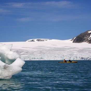 Kayak near glacier front and icebergs in Jostedal, Norway