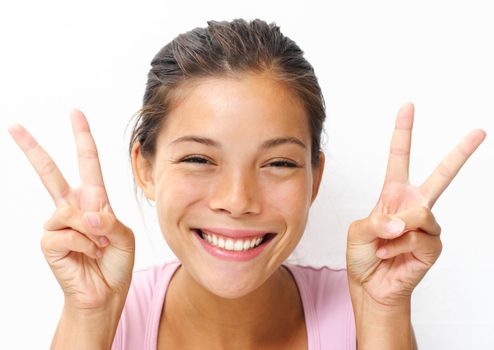 Cute young woman showing the peace / victory hand sign.