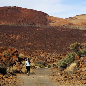 Girl running alone on the volcano Teide on Tenerife
