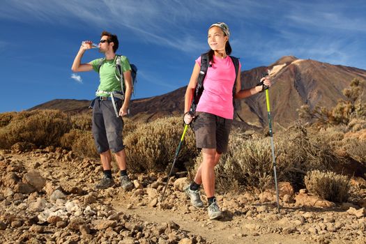 Hiking. Young couple hiking / backpacking in very scenic and beautiful volcanic landscape on the volcano, Teide, Tenerife, Spain. 