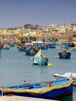 Traditional Malta boats moored at the picturesque fishing village of Marsaxlokk in Malta