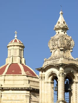 A medieval clocktower against blue sky and clouds