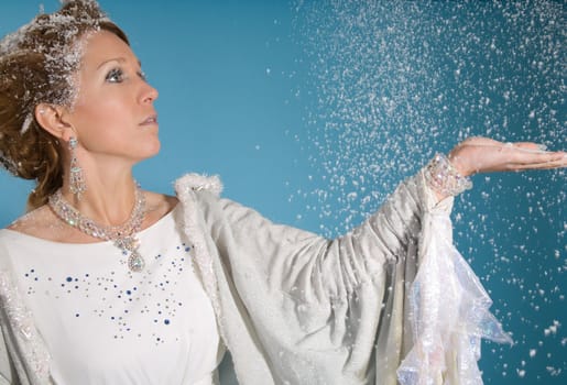 Beautiful blond woman with snowy costume on blue