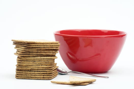 A stack of crackers  and red cup over white