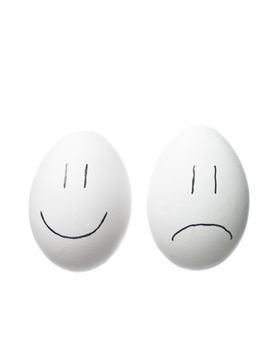 Sad face and a happy face painted on white eggs isolated on white