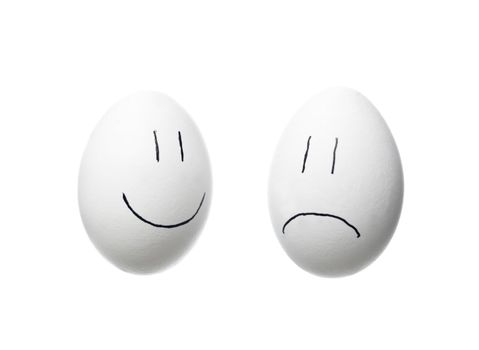 Sad face and a happy face painted on white eggs isolated on white