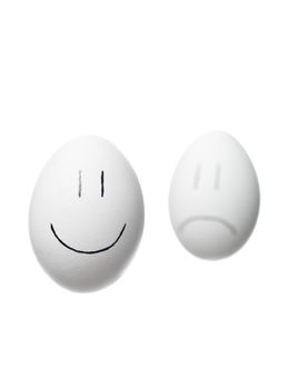 Sad face and a happy face painted on white eggs isolated on white