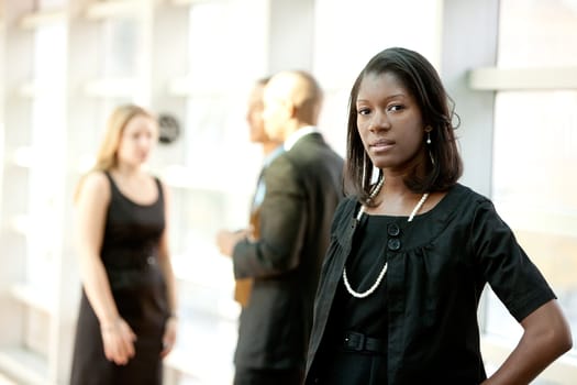 An african american business woman with colleagues in the background