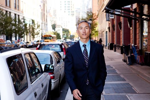 A business man in a city setting on a sidewalk