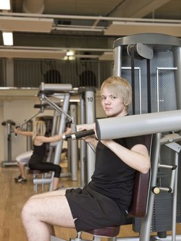 Young man using an exercise machine at a health club