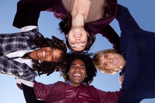 A group of friends hugging in a circle and looking at the camera