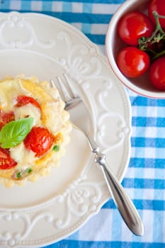 Small puff pastry pie with cherry tomatoes, brie, peas and basil