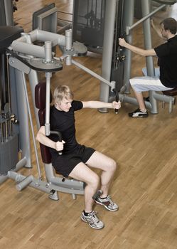 Young man using an exercise machine at a gym.