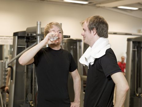 Two young men talking at a healthc club