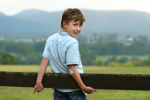 A young happy boy in the paddock on an overcast afternoon. f 3.5