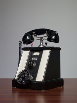 antique telephone on a desk against a grey background